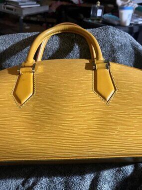This is a yellow Louis Vuitton Jasmine handbag crafted from durable Epi leather.